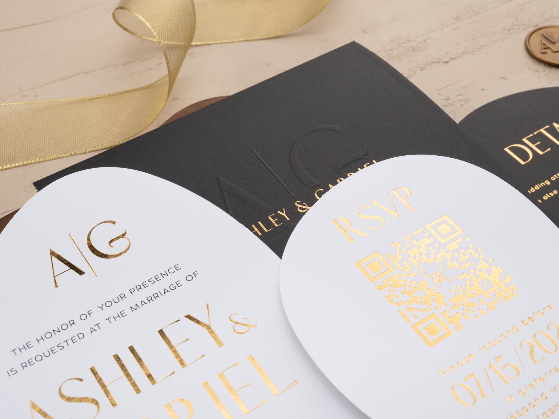 Close-up of gold foil text and embossed monogram on black envelope