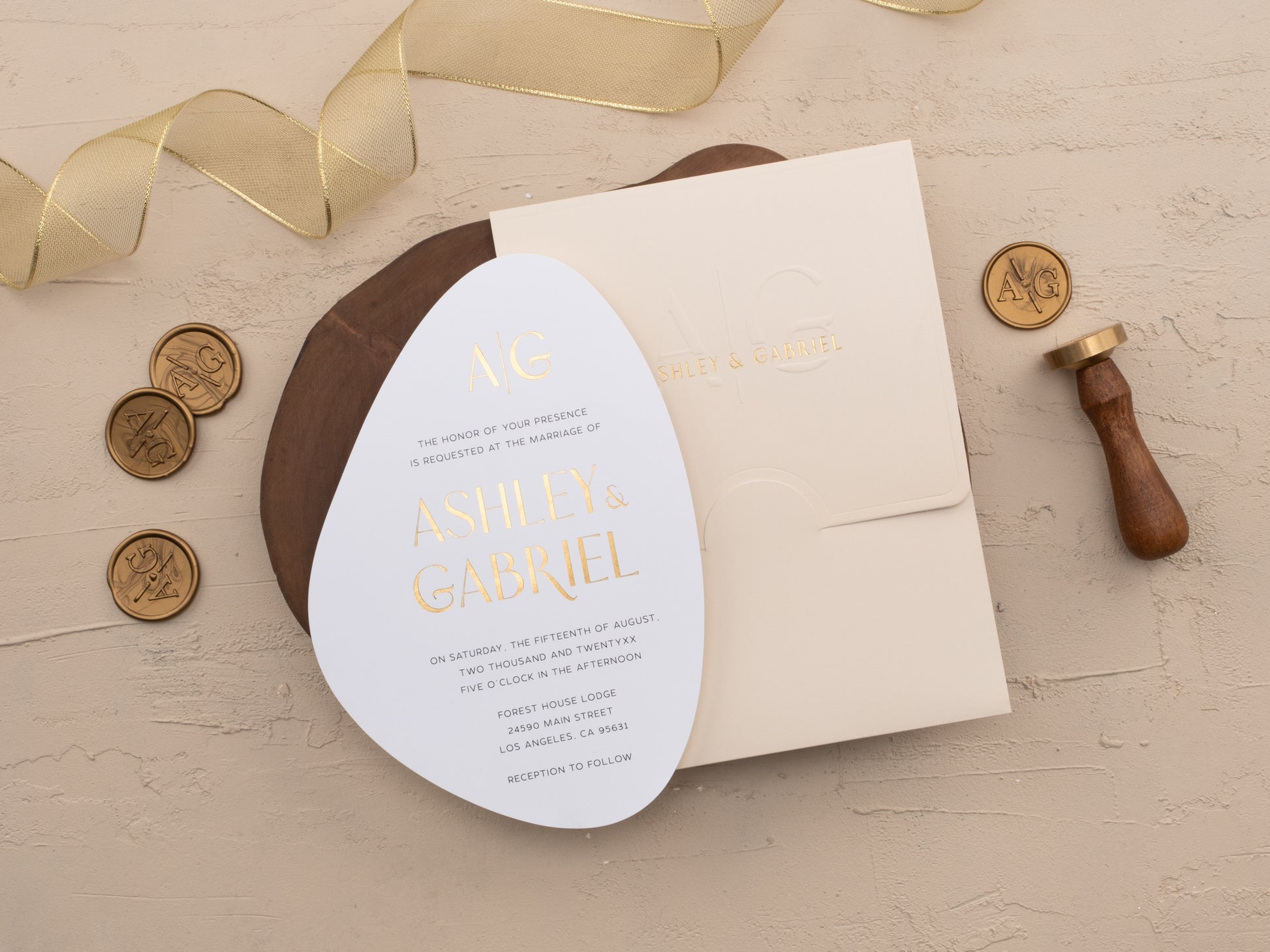 Embossed initials on ivory envelope, paired with gold foil oval invitation