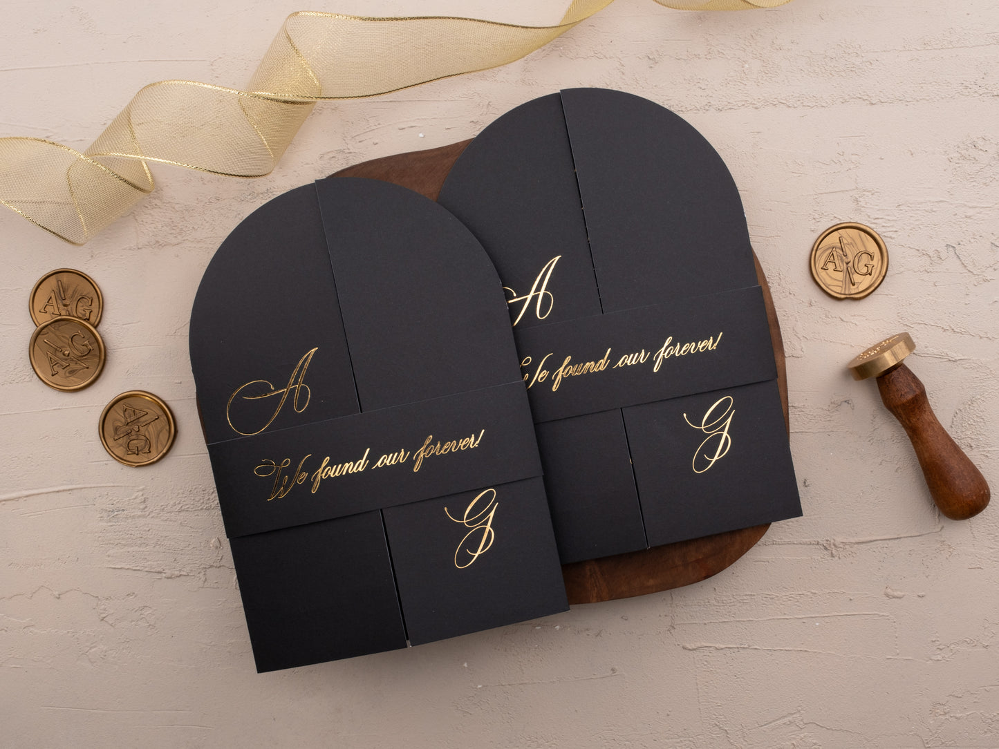 Closed black wedding invitation with gold foil belly band