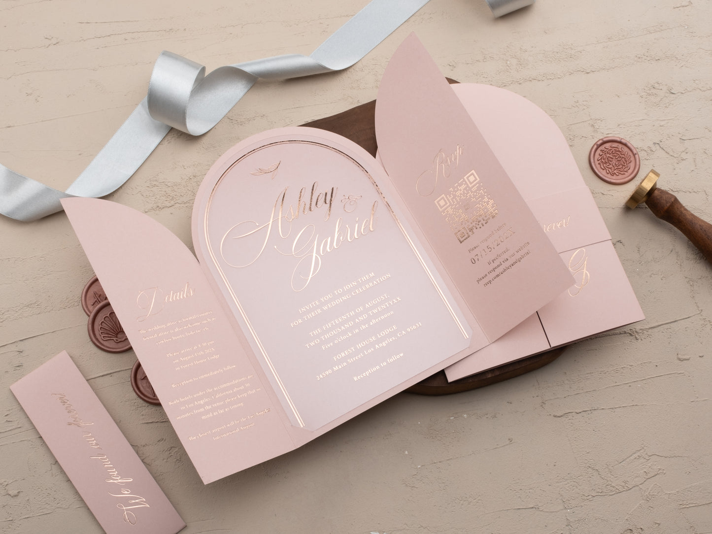 Blush pink arch folded acrylic wedding invitation with rose gold foil and matching RSVP card, styled with wax seals.