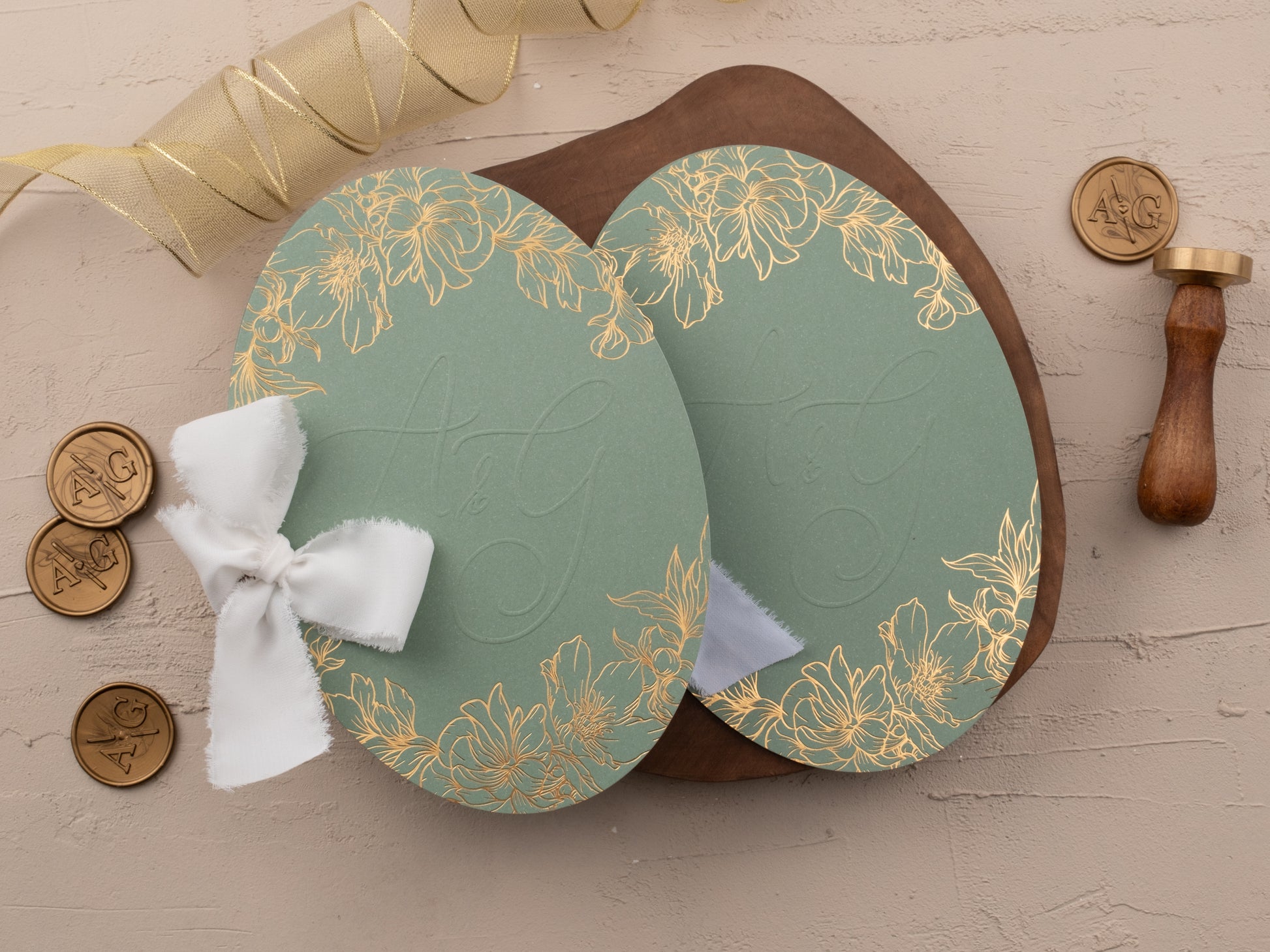 Close-up of gold foil invitation suite with sage green floral jacket