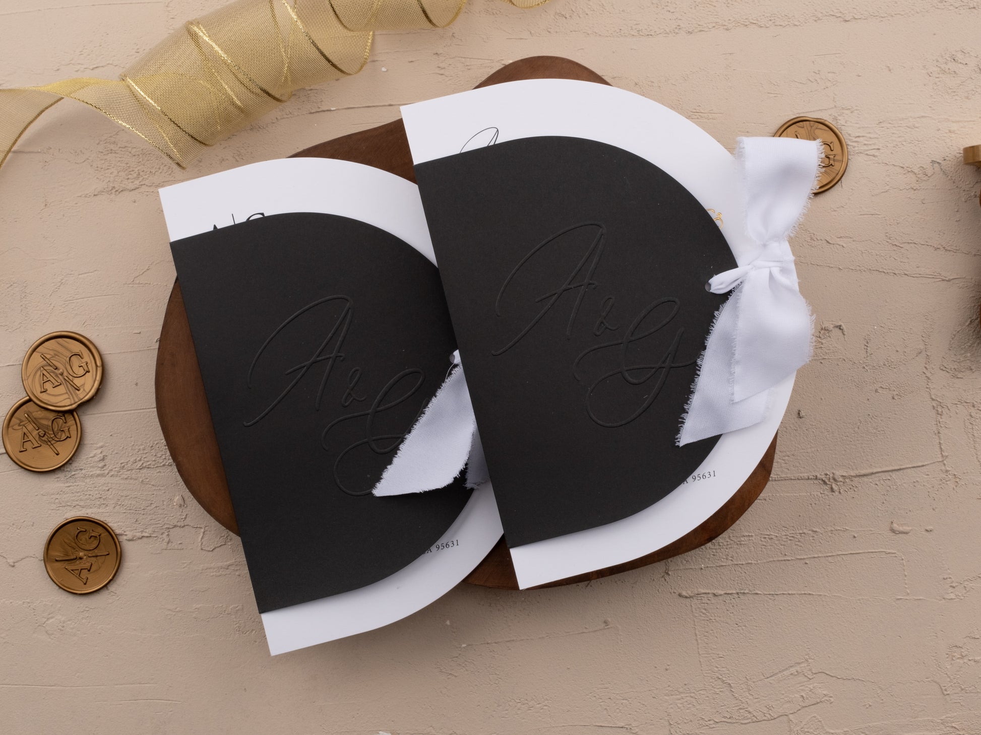 Black and gold wedding invitation with embossed initials