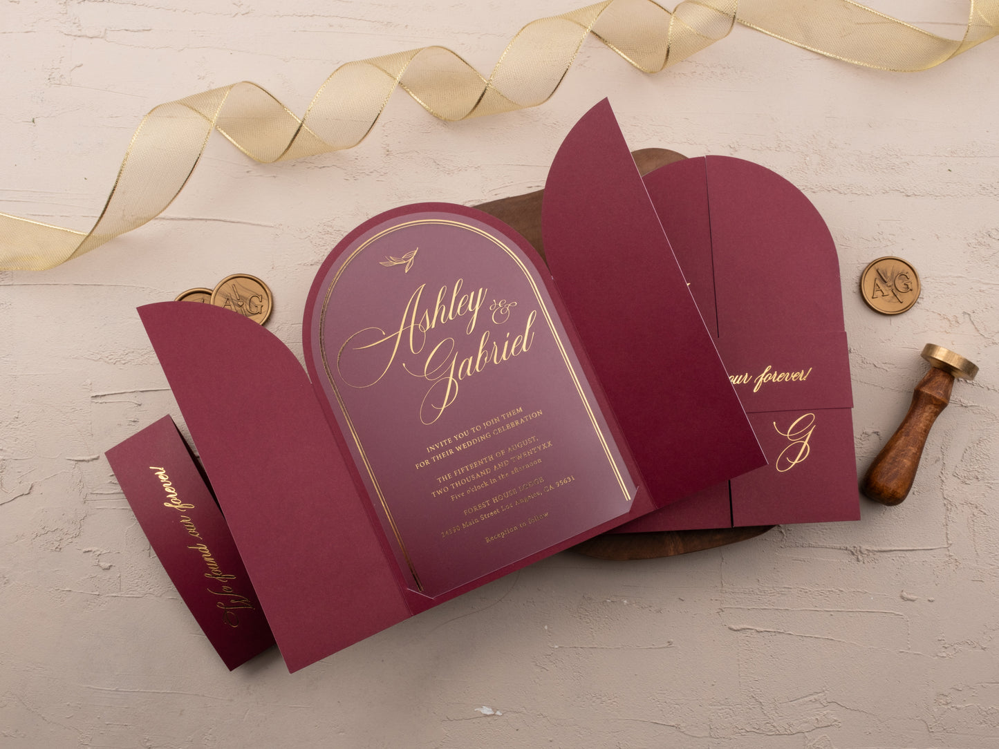 Open burgundy wedding suite with foil-stamped details