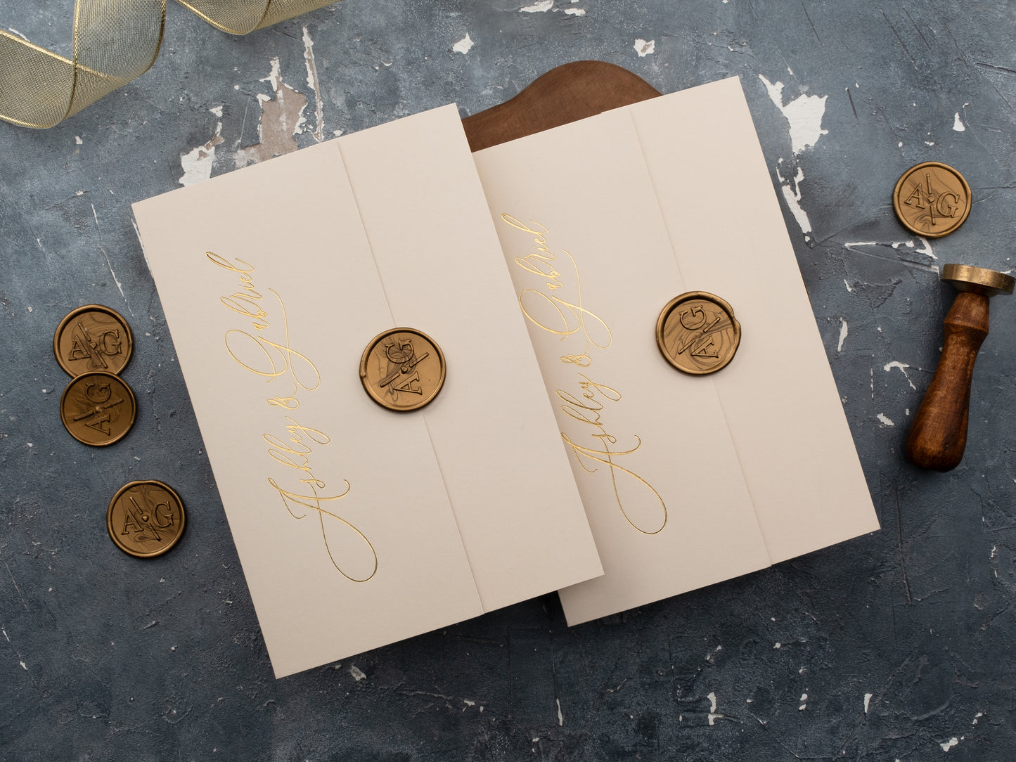 Closed wedding invitations with wax seal and gold foil names