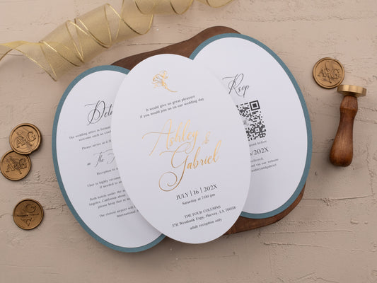 Gold foil wedding invitation next to floral embossed dusty blue jacket
