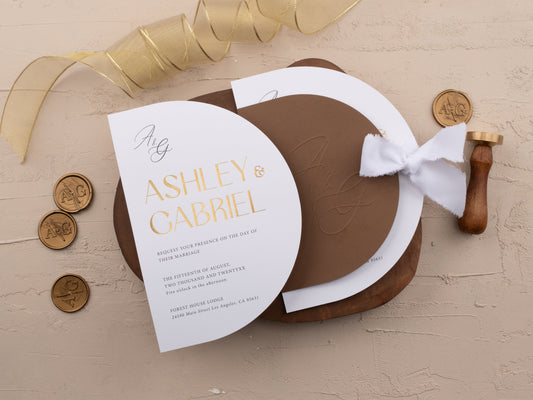Modern brown wedding invitation with gold foil arch design, white insert card, ribbon tie, and QR code RSVP displayed on a neutral background
